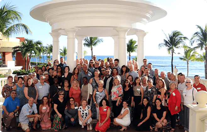 A group of agents outside surrounded by palm trees