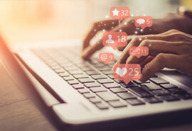 Person typing on a keyboard with social media notifications all over