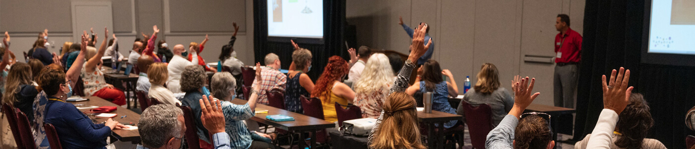People raising their hands in a classroom