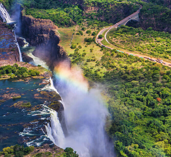 Rainbow over Victoria Falls in Zimbabwe, sunny day in Africa