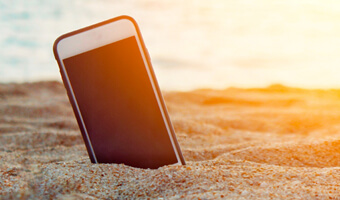 Cell Phone in the sand at sunset.